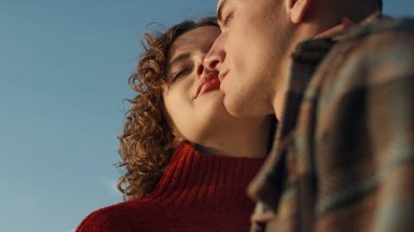 Sevgi dolu çift kameraya düşük açıyla poz veriyor. Gülümseyen kadın ve erkek dışarıda kucaklaşıyorlar. Kapanış kızı ve yüzlerine dokunan adam. Aşıklar birbirlerine şefkat gösteriyorlar. Duygular konsepti 