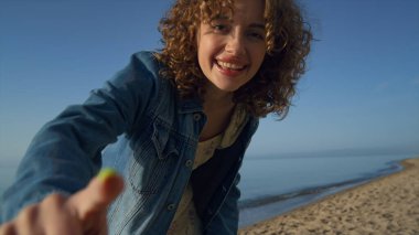 Gülümseyen kadın akıllı telefondan arkadaşıyla görüntülü sohbet ediyor. Sahilde el sallayan neşeli kız. Heyecanlı bayan deniz manzarasını video ile gösteriyor. Kadın tatilde mutlu hissediyor. Çevrimiçi kavram