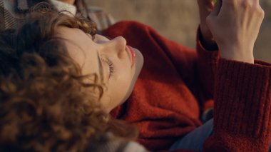 Genç çift gündoğumu kumsalında vakit geçiriyor. Neşeli kıvırcık saçlı kız akıllı telefon yapıyor. Cep telefonu kullanan barışçıl bir kadın. Mutlu aşıklar suset sahilinde dinleniyor. Boş zaman konsepti