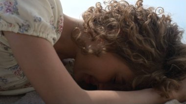 Kaygısız genç bayan güneşli sahilde rahatla. Yaklaş. Çekici kıvırcık kadın yaz haftasonu kumsalında yatarken gülümsüyor. Mutlu genç kız güzel bir elbise giyerek gün ışığının tadını çıkarıyor. Sakin eğlence konsepti. 