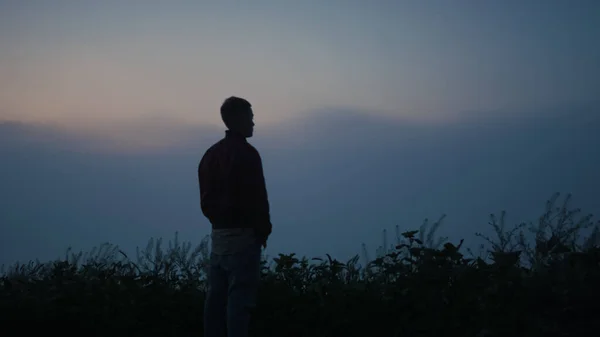 宁静的人在早晨欣赏着雾蒙蒙的风景 一个沮丧的家伙在日出的时候站在山上 忧郁的男人在秋天看着神秘的地平线 男人独自感受与自然的和谐 — 图库照片