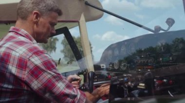 Professional aviation engineer sitting cabin ultralight airplane making preflight procedure close up. Experienced aviator preparing small parked aircraft to training flight. Plane piloting concept.