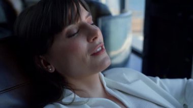 Dreamy woman face relaxing office armchair closeup. Smiling european businesswoman planning enjoying in formal journey close up. Top manager corporate employee resting at work break in hotel lobby 