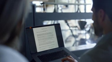 Man typing laptop screen with text dark office closeup. Unknown coworkers signing contract rear shot. Boss director correcting work papers computer. Focused businesspeople reading agreement documents