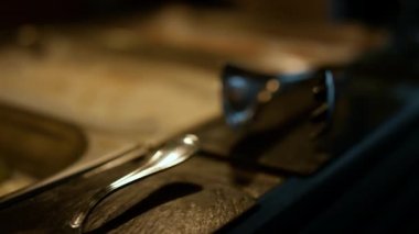 Lüks öğle yemeği için modern otel restoranının çatal bıçak takımı. Paslanmaz çelik çatal bıçak maşası ve açık büfe masa arka planında spatula. Yemek konsepti.