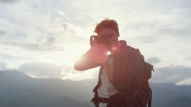 Closeup smiling traveler photographing nature on camera objective outdoors. Ginger tourist shoot mountains picturesque landscape on trip. Professional photographer make photo lens. Leisure concept.