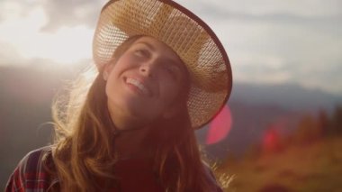 Hiking millennial look camera in mountains sunrise. Portrait of beautiful girl dream think outside on summer holiday. Excited woman smiling feel happy on nature. Natural beauty recreation concept.