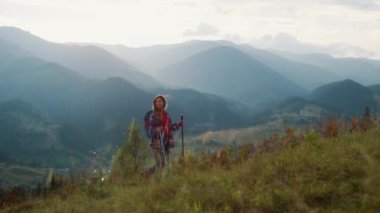 Backpacking woman explore mountains peak. Inspired tourist walk mountains alone. Nature traveler trekking on hike trail expedition outside. Excited girl look beautiful landscape view. Travel concept.