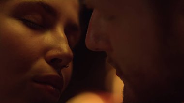 Romantik çift yüzleri yakın planda flört eder. Aşıkların portresi şehvetli bir aşk randevusu gibidir. Şefkatli kız arkadaş şöminenin keyfini çıkarıyor. Sevgililer günü sevgililer günüdür. Romantik bakım kavramı