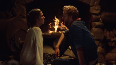 Samimi aşıklar kır evinde şömine dinleniyor. Romantik bir akşamda flört eden sevimli bir çift. Yakın mesafeden gülümseyen sevgili, kış tatilini birlikte tatil evinde geçirir. Boş zaman kavramını seviyorum.