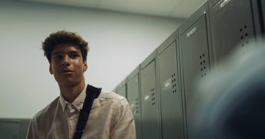 Dolapların okul koridorunda duran sevimli Hintli çocuk. Brunet 'li okul çocuğu tatilde arkadaşıyla konuşuyor. Neşeli, gülümseyen, koyu saçlı öğrenci üniversite koridorunda sınıf arkadaşlarıyla sohbet ediyor. Gençlik iletişimi