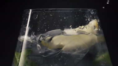 Limonlu nane suyu yere düştü. Buzlu soda ve makroda limon dilimi. Şarap kadehinde köpüklü kokteyl hazırlıyorum. Yaz ferahlatıcı içecek konsepti