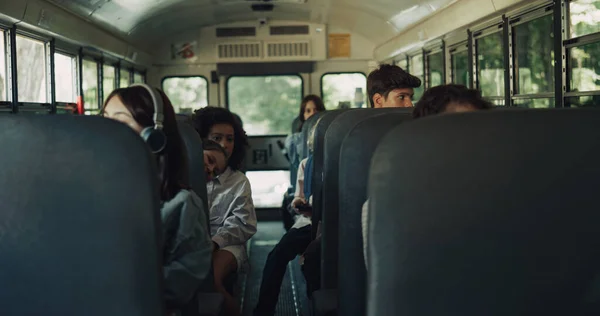 多様な学生が一緒にスクールバスに座っています 勉強の後 多人種間のティーンエイジャーが家に帰る 学術シャトルに乗って 複数の民族の学校の子供たちのグループ 公共教育交通の概念 — ストック写真