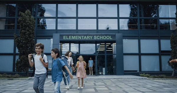 Diverse Pupils Leaving Elementary School Building Happy Children Talking Smiling — Stockfoto