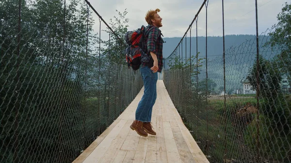 남자는 하이킹으로 포장한다 레드헤드 관광객 다리에서 뛰어내렸어 조심스럽게 여행하는 사람은 — 스톡 사진