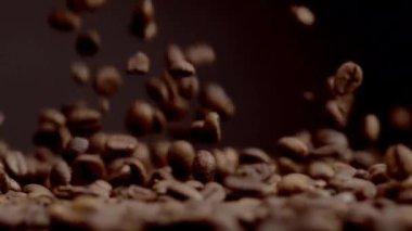 Closeup coffee beans fall on heap aromatic harvest. Brown fresh seeds pouring super slow motion macro view. Roasted grains ready for grinding. Perfect ingredient for preparing strong morning beverage.