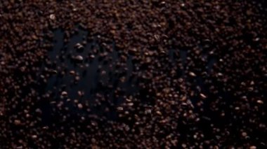 Magic falling fragrant coffee grains on dark background. Premium roasted beans flying in super slow motion. Aromatic coffee seeds for energetic caffeine drink. Delicious arabica tasty robusta concept