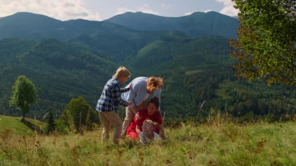 Playful Family Falling Green Grass Mountain Hill Cheerful Couple Playing — Stockvideo