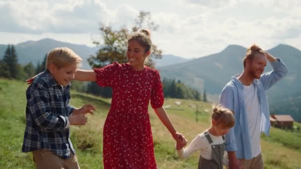 Веселые Родители Улыбаются Гуляя Детьми Зеленой Горной Долине Беззаботная Семья — стоковое видео