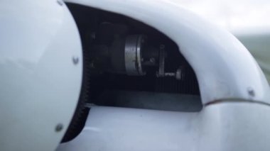 Closeup small plane engine under white aircraft hood turned off. Technical part of ultralight private airplane parked on aerodrome after flight. Modern components air transport. Aviation concept.