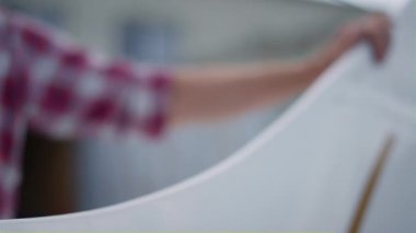 Unknown professional pilot hand touching airplane white wing before flight close up. Unrecognizable aviator inspecting plane parts looking for damages on aerodrome. Flying training aircraft concept.