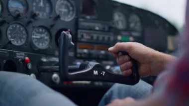 Aviator turning steering wheel small private airplane cockpit on aerodrome close up. Unknown aviation engineer sitting plane cabin driving lightweight aircraft to parking. Air transport concept.