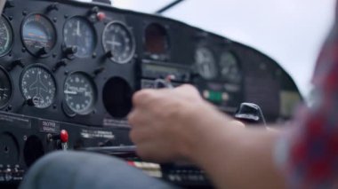 Hand airman driving airplane checking indicators modern control panel before flying close up. Unknown man aviator preparing aircraft to flight starting plane using key. Aviation skills concept.