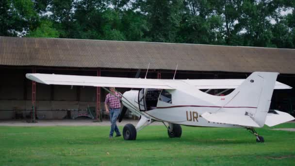 Aviator Inspecting Small White Airplane Landed Countryside Airdrome Professional Man — Vídeo de Stock