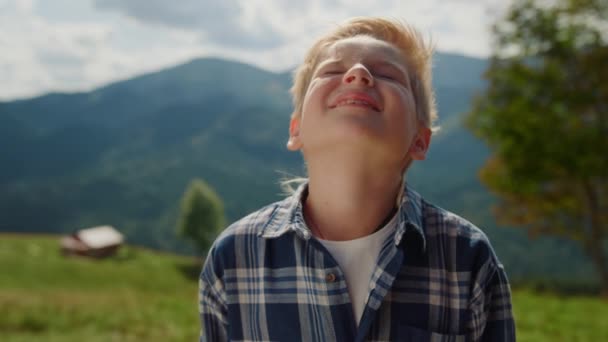 Closeup Little Boy Enjoying Sunlight Raising Head Sky Summer Mountains — Stock video