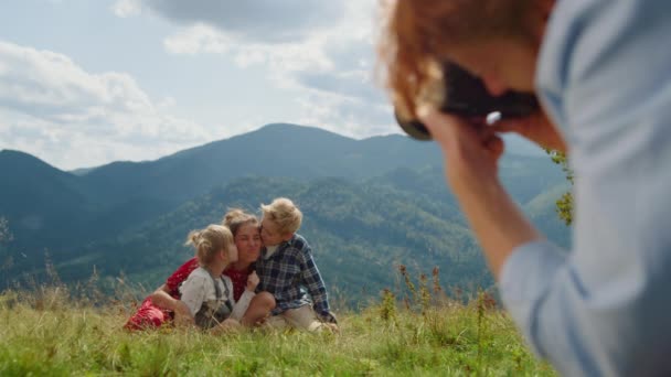 Вид Ззаду Рудий Чоловік Фотографує Усміхнену Жінку Дітьми Зелених Горах — стокове відео