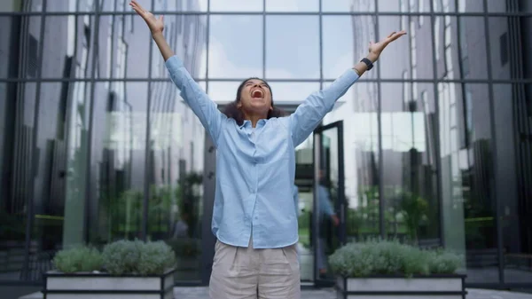 在拥挤的写字楼市中心 赢得了一位女商人尖叫着举手致意 成功的女人站在外面庆祝当代玻璃建筑的成就 幸运日的概念 — 图库照片