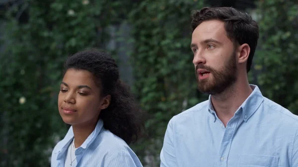 Two employees walk talk at business district closeup. Corporate people concept. Serious bearded man manager discussing project with coworker. Focused african american woman director explaining case.