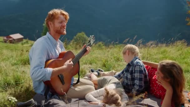 Redhead Young Father Playing Guitar Wife Children Green Meadow Happy — Vídeo de Stock