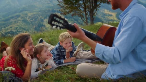 Side View Redhead Father Playing Guitar Smiling Woman Children Lying — Vídeo de Stock