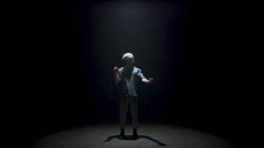 Man enjoying virtual reality simulation in goggles. Focused gamer selecting invisible digital objects in dark room. Metaverse guy immersing hi tech world in light. Futuristic performance concept.