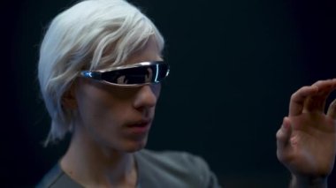 Digital glasses man travelling metaverse or outer space closeup. Amazed gamer in 3d headset gesturing touching while playing video games black background. Modern technologies entertainment concept