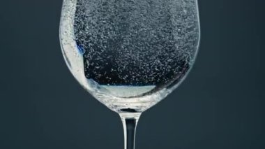 Air bubbles rising cup surface closeup. Pure refreshing water in transparent glass at dark background. Little liquid sparkling dissolving disappearing in beautiful jug. Mineral hydration concept.