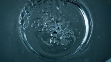 Top view water pouring transparent cup closeup. Diverse air bubbles flowing exploding pure liquid surface. Refreshing cool drink bubbling filling glass jug. Mineral resources health care concept.