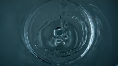 Pure water filling glass top view closeup. Crystal clear liquid stream bubbling in transparent cup bottom. Diverse tiny air bubbles rising exploding on beverage surface. Health care vitality concept.