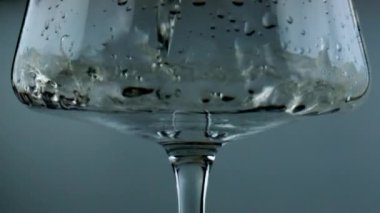 White wine filling glass closeup. Sparkling golden alcohol pouring splashing in goblet. Beautiful shot of air bubbles flowing tasty sauvignon in transparent cup. Romantic evening preparation concept