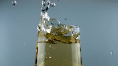 Ice cube falling wine goblet closeup. Cool alcohol beverage splashing in glass. Beautiful commercial shot of refreshing liquor drink waving in transparent cup. Party celebration relaxation concept.
