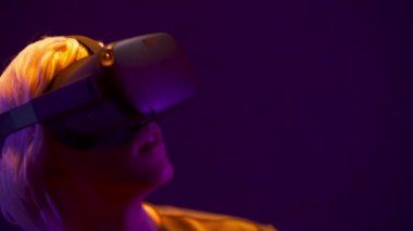 Spellbound man using augmented reality glasses closeup. Male VR headset playing in magic atmosphere of neon rays. Impressed gamer digital interactive art performance. Future entertainment concept