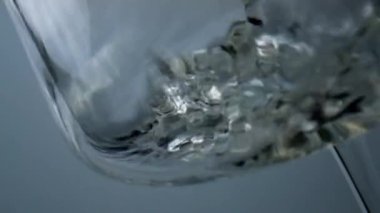 Closeup white wine bubbling splashing in goblet. Air bubbles flowing liquid. Golden fizzy beverage falling into beautiful transparent glass. Sparkling drink in cup. Sauvignon party celebration concept