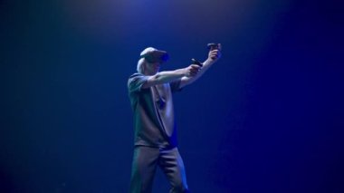 Skilful gamer playing shooter in digital metaverse world. VR goggles man having fun in futuristic game neon colourful background. Teenager enjoying new experience. Technologies and entertainment 