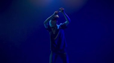 Blonde man playing virtual world game. Focused gamer holographic augmented reality glasses pretending draw bow enjoying in neon light. Guy VR digital space. Metaverse 3d modern technology concept