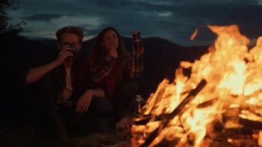 Family couple warm bonfire on night camp. Young lovers cuddle together outdoors closeup. Cheerful husband wife enjoy romantic evening date on honeymoon anniversary trip. Active leisure love concept.