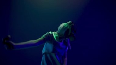 Spellbound girl using vr glasses closeup. Virtual reality headset woman watching movie playing videogame slow motion. Amazed gamer person taking new experience future technologies neon light 