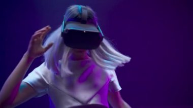Amazed girl enjoying vr glasses experience closeup. Virtual reality headset woman watching movie playing videogame slow motion. Gamer person having fun with futuristic technologies neon light 