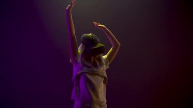 Student woman dancing moving metaverse game closeup. Girl getting experience using VR headset glasses in neon multi coloured place. Millennial gamer playing enjoying 3D simulation alone slow motion