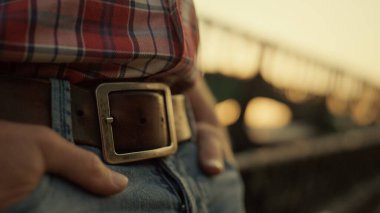 Agronomist gün batımında el cebini ayakta tutar. Yakın plan çekimde birleşir. Bilinmeyen çiftçi buğday kırsalında harman makinesinin yanında dinleniyor. Kırsal çevrede altın bir akşam. Tarım sektörü iş sonu kavramı.